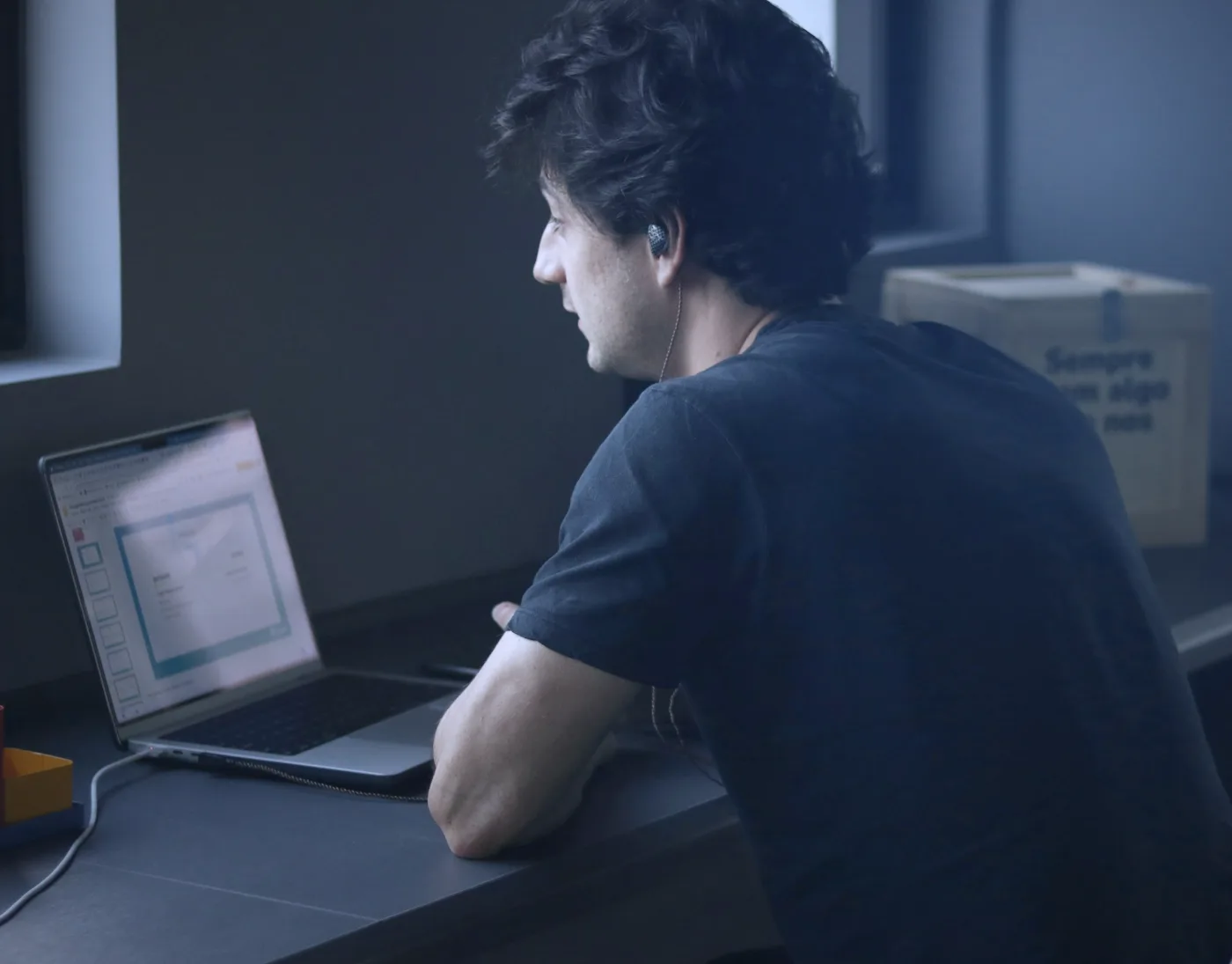 Online store owner at a laptop beside shipping boxes